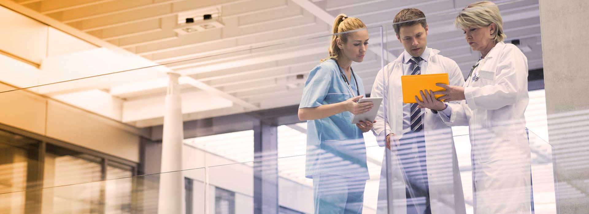 Ein Arzt, eine Ärztin und eine Pflegerin beraten sich in einem Krankenhaus