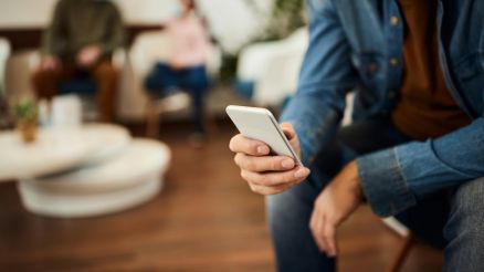 Ein Patient nutzt die GesundheitsID auf seinem Handy in einerm Wartezimmer einer Praxis / AKQUINET