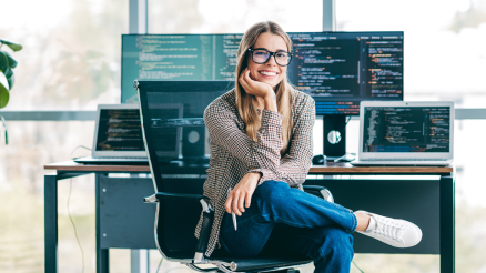 Eine junge Programmiererin sitzt am Schreibtisch